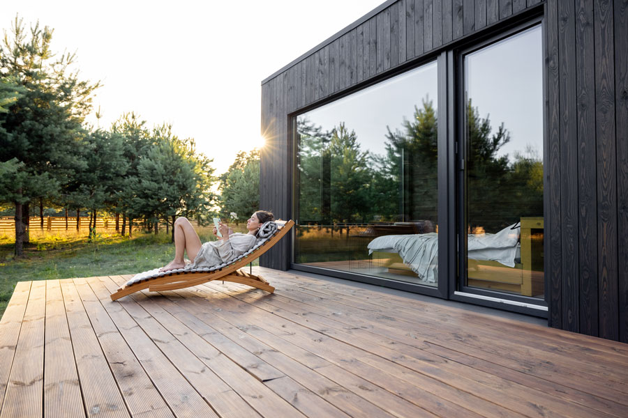 femme qui lit dans un transat sur une terrasse en bois de pin - Aménagement de terrasse en bois traité